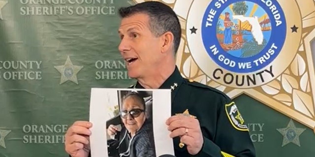 Orange County Sheriff John Mina holds up a picture of Dolores Padilla Marrero during a press conference on Thursday